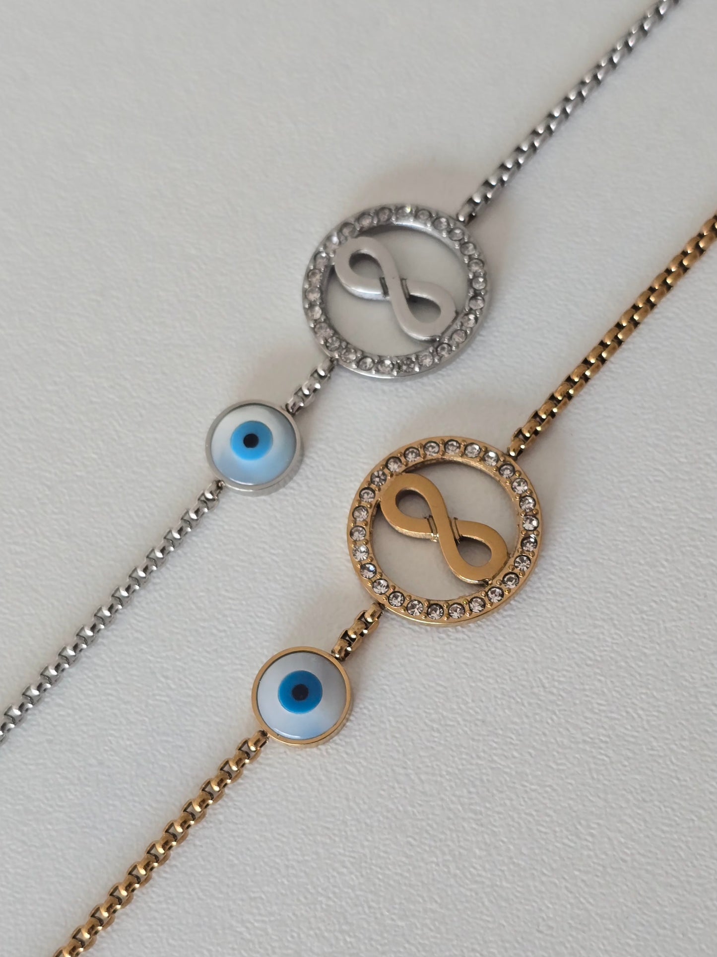 bracelet cercle infini serti de strass et oeil bleu, coloris argenté et doré