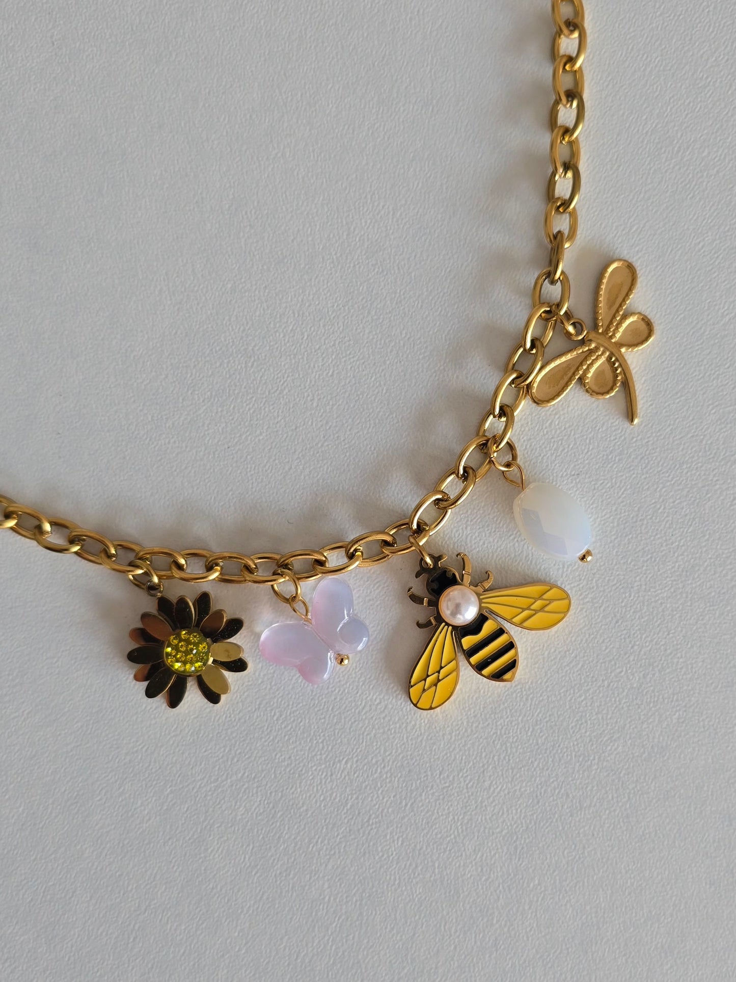 Bracelet Sunny en acier inoxydable doré avec charms fleur, papillon, abeille, perle et libellule
