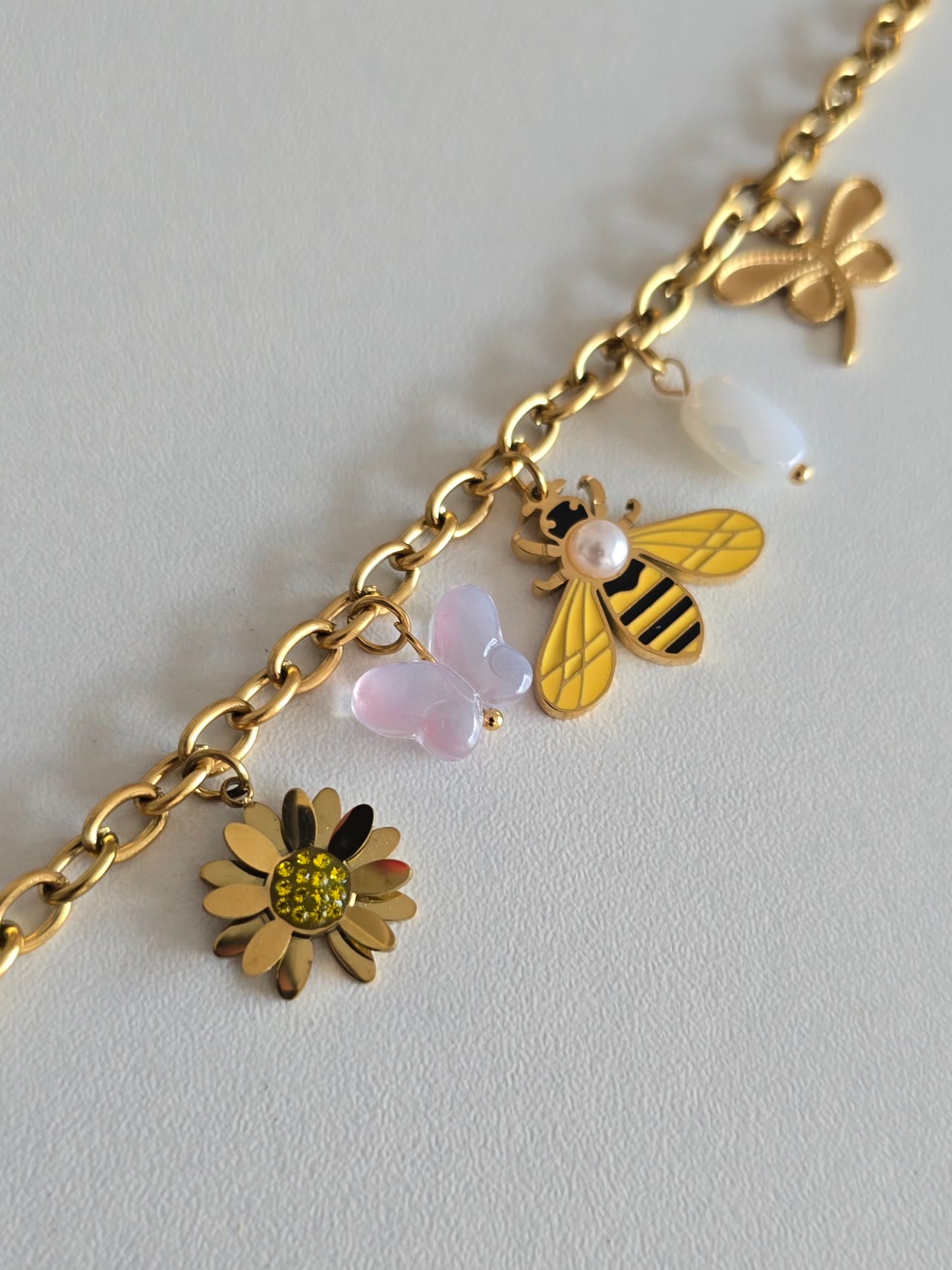 Bracelet tendance doré avec pendentifs : libellule, papillon rose, fleur jaune et abeille nacrée