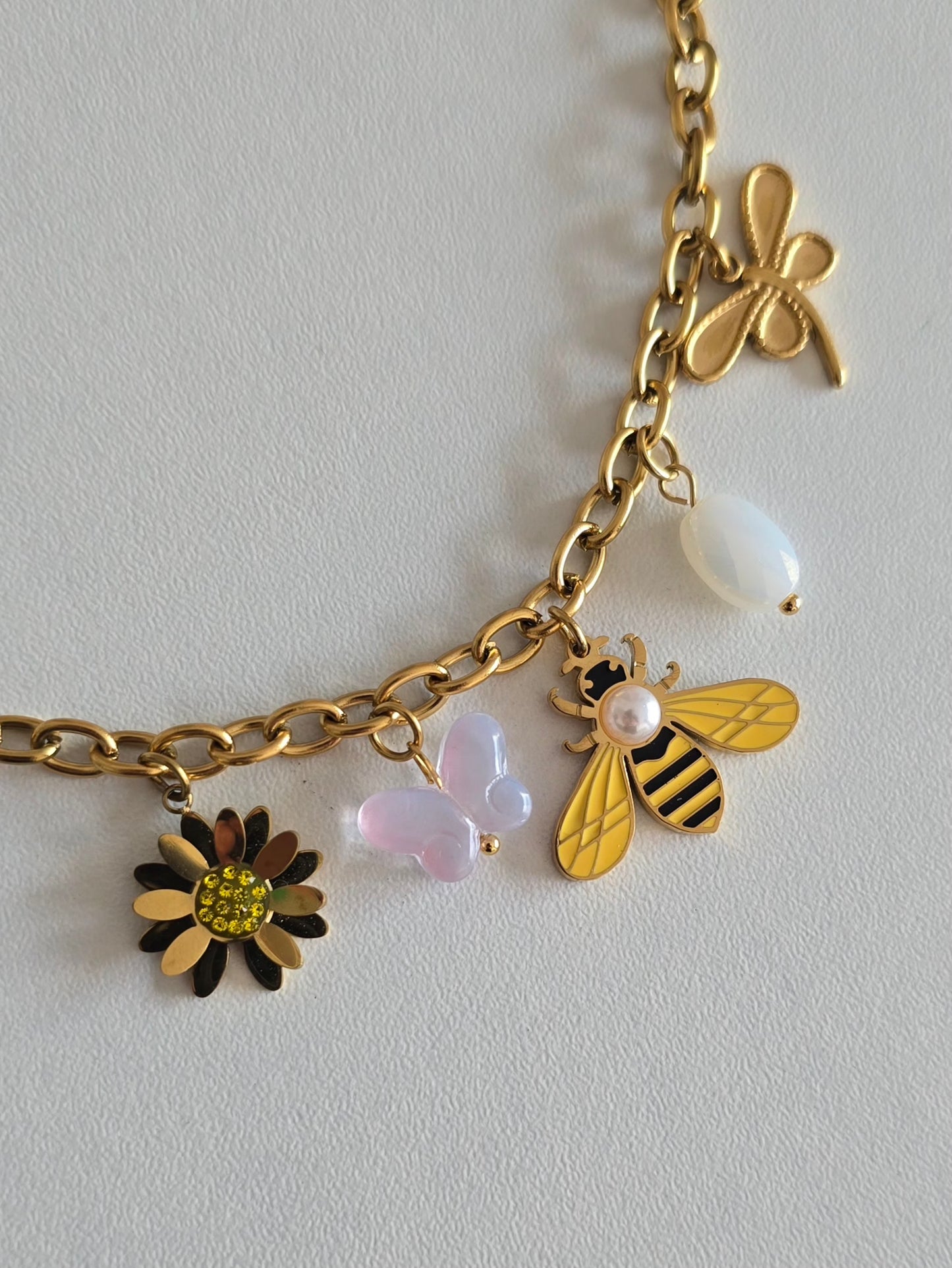 Bijou féminin doré avec pendentifs délicats représentant la nature d'été