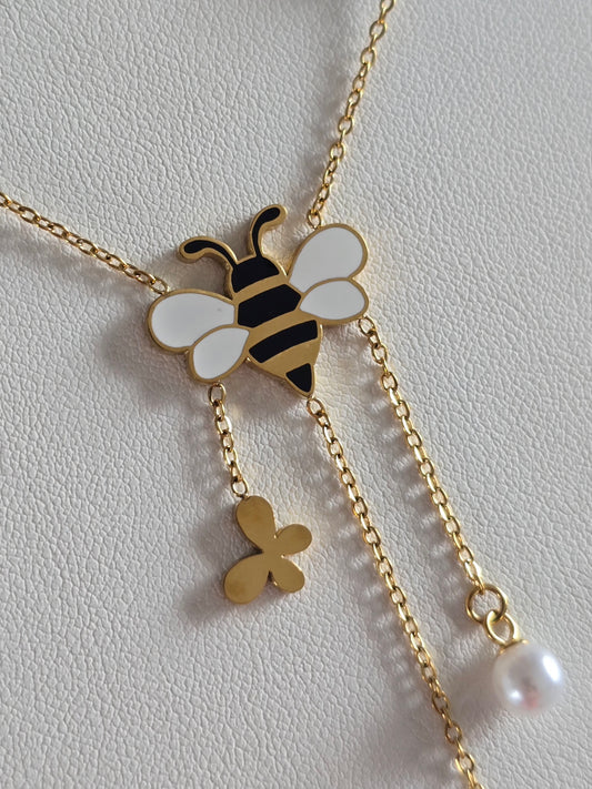 gros plan sur pendentif abeille noir et blanche du collier Maya