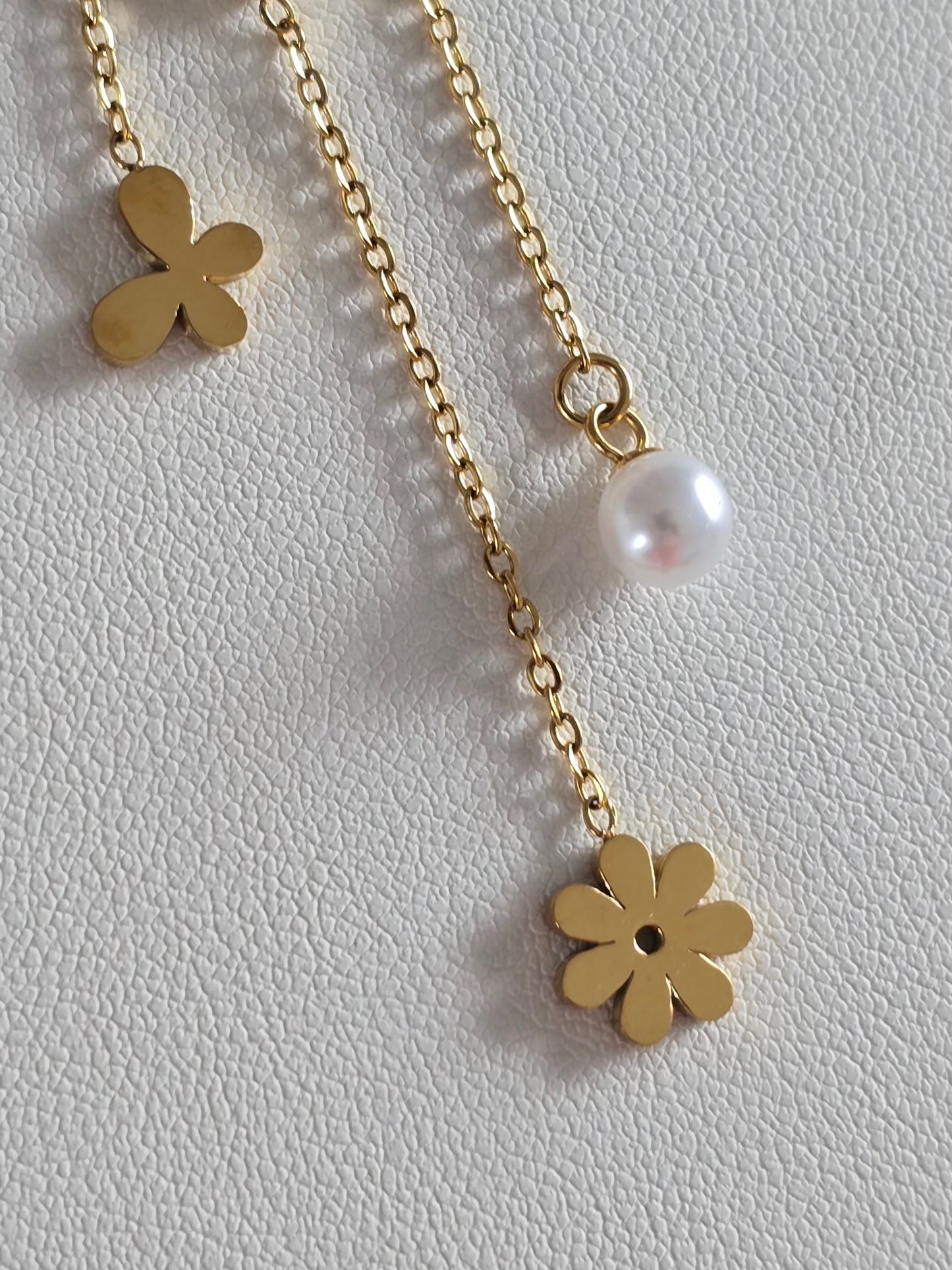 zoom des pendentifs papillon, fleur sous le collier abeille Maya