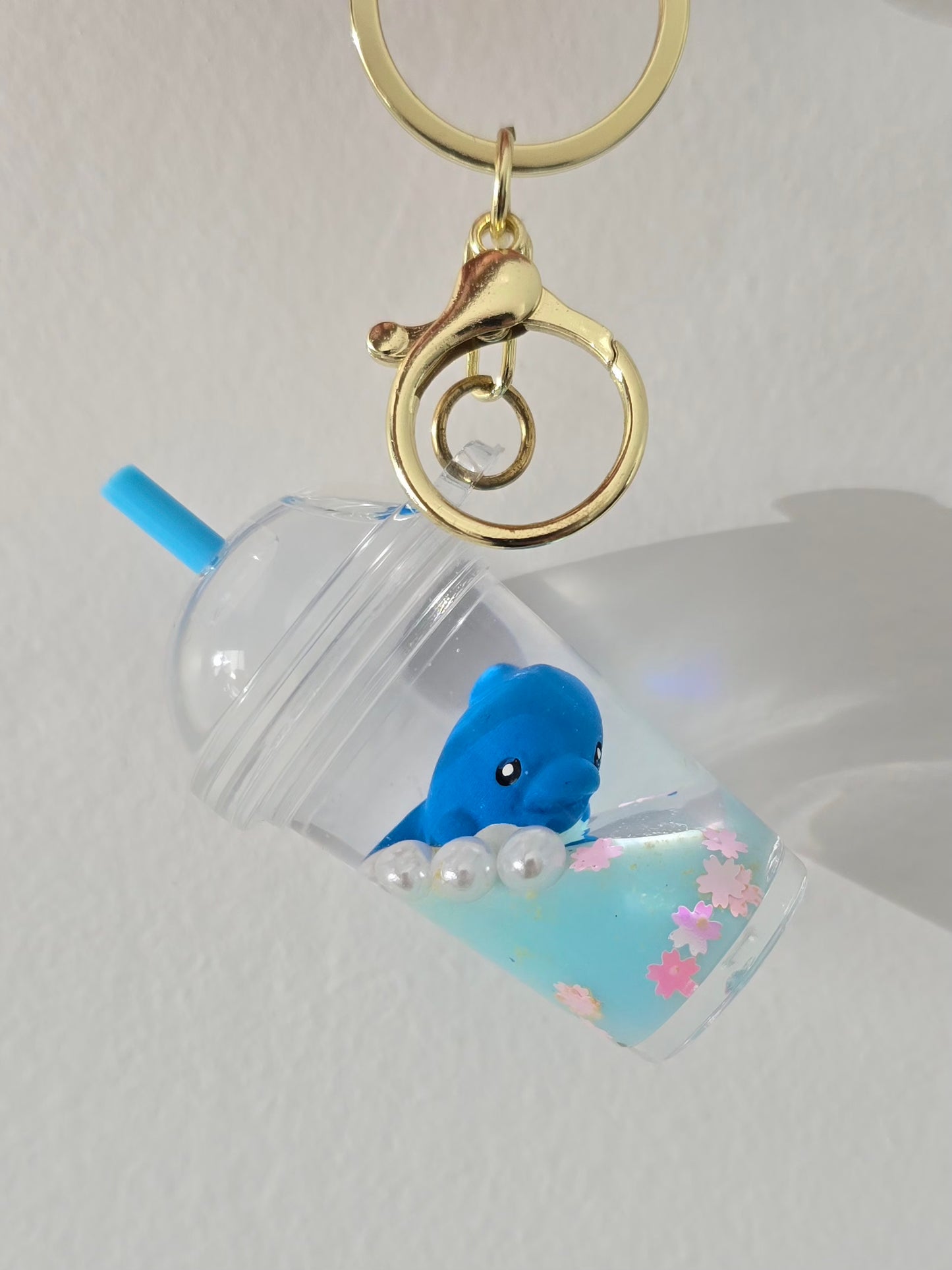 bijou kawaii bleu avec dauphin océan et liquide scintillant
