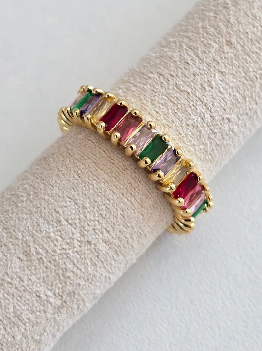 Bague Lumicolor dorée avec pierres multicolores présentée sur support