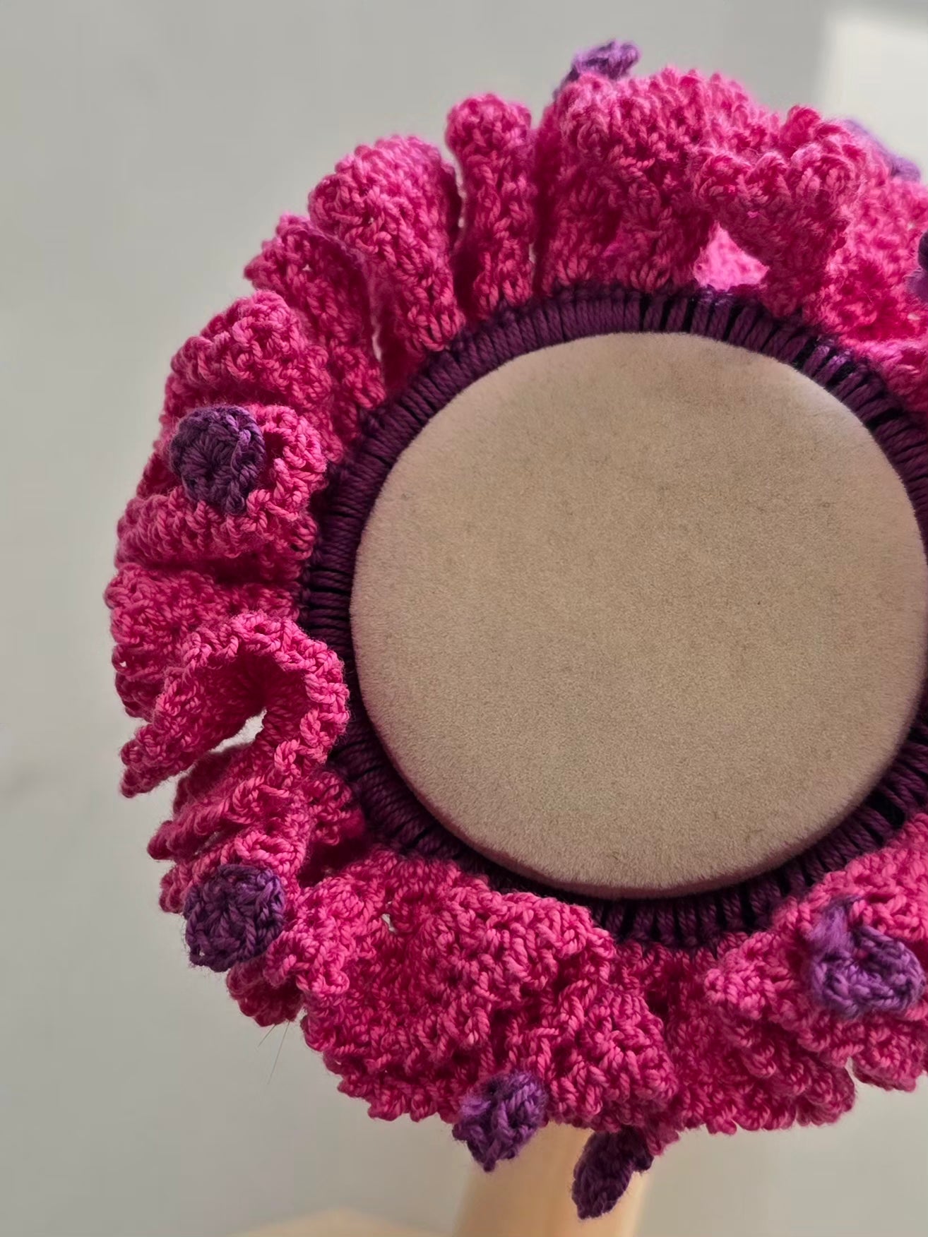 Chouchou rose vif en coton avec reliefs et finitions violettes.
