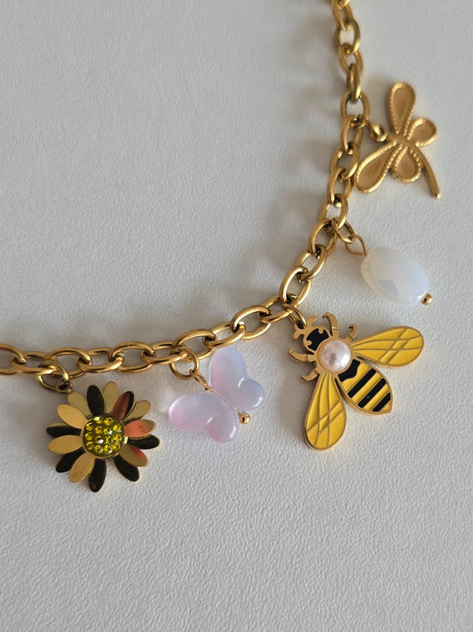 Bijou doré ajustable 16,5 + 4 cm, orné de pendentifs nature : fleur, papillon, abeille et libellule.