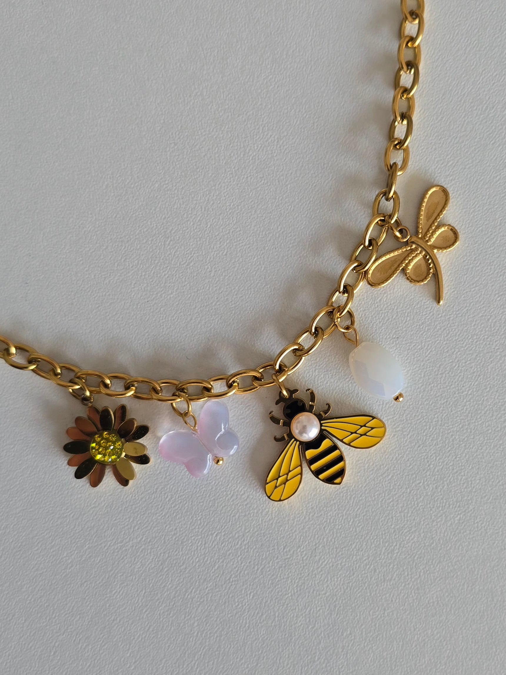 Bracelet doré femme avec abeille émaillée jaune et noire, papillon rose, perle blanche et fleur