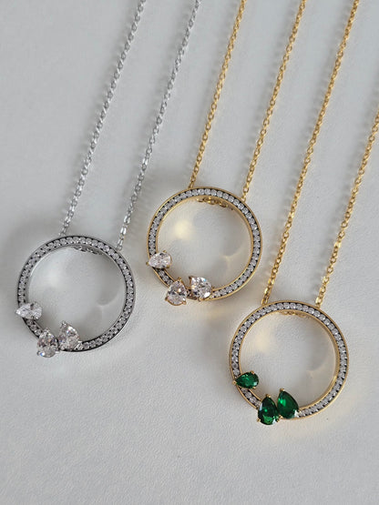 Collier Oriana en acier inoxydable : cercle pavé de strass, décliné en argenté, doré et doré/vert. Élégant, durable et intemporel.