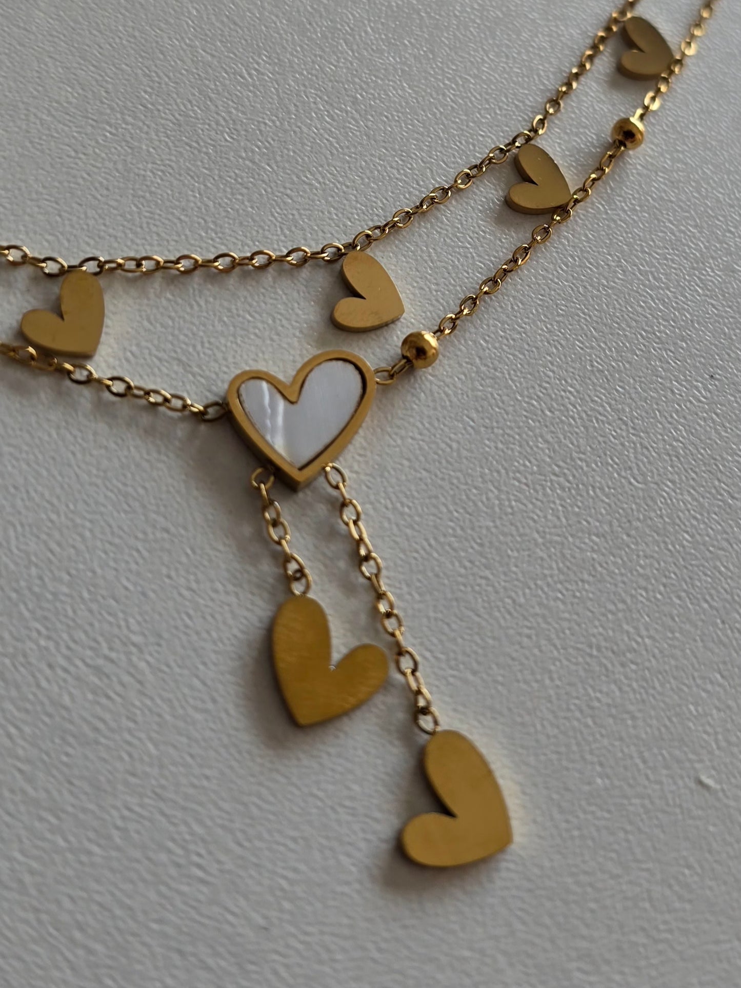 chevillier élégante double chaîne dorée avec coeur blanc irisé et pendentifs coeurs