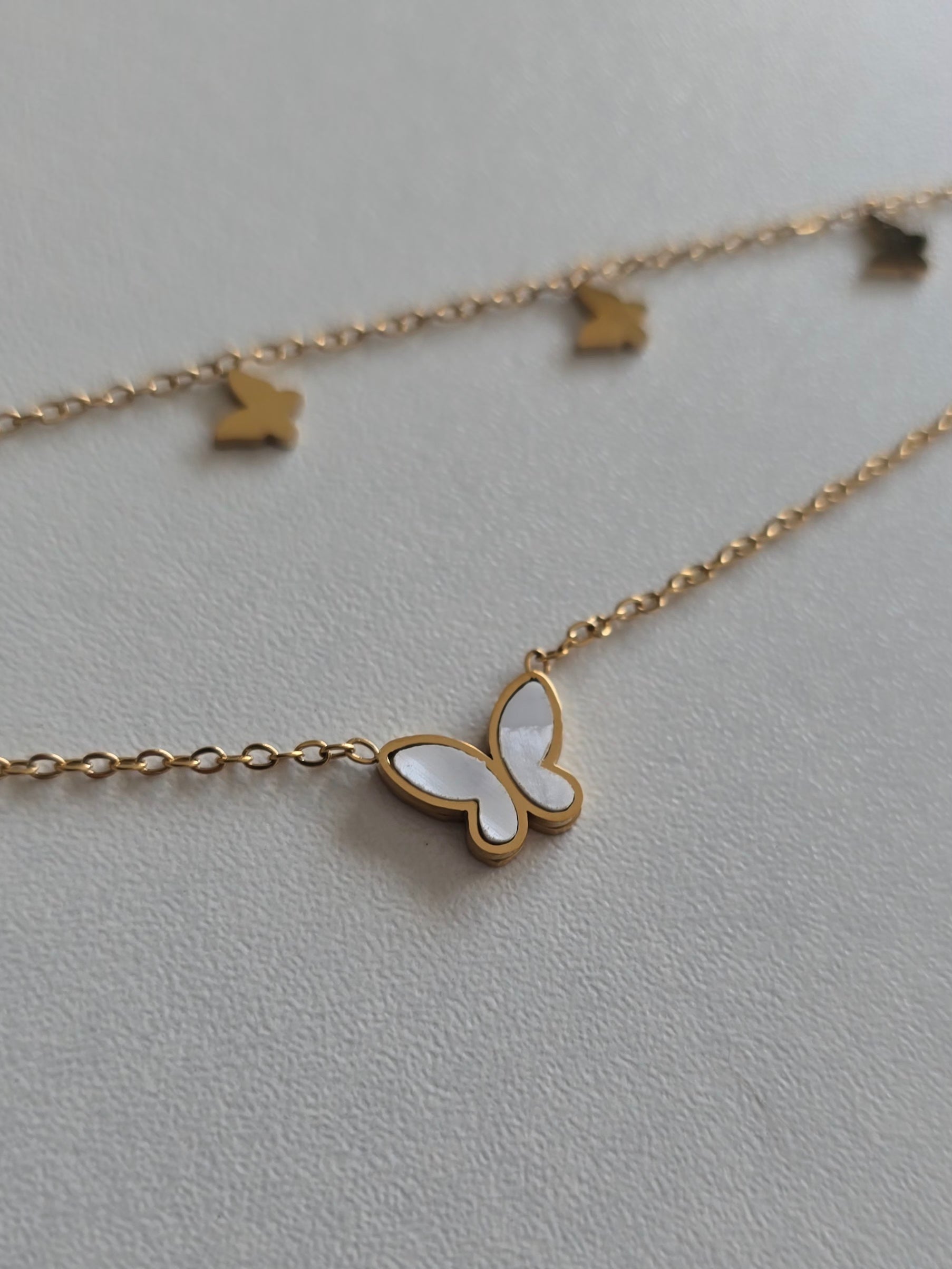 bracelet de cheville femme doré avec pendentif papillon blanc irisé 