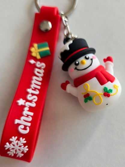 détail du porte-clés Snowy avec sourire, houx et écharpe rouge
