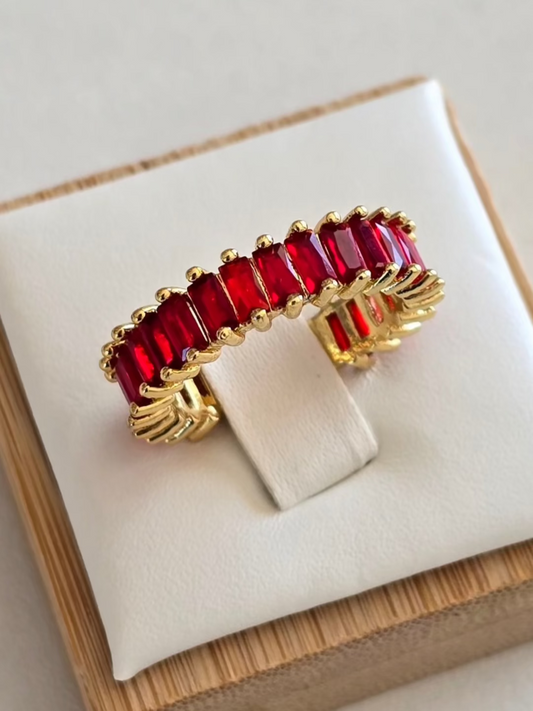 Gros plan de la bague Lumired en acier inoxydable doré et pierres rouge éclatantes 
