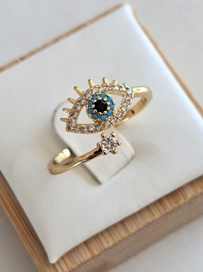 Bague Oryna dorée avec oeil protecteur serti de strass argentés, bleus et noirs