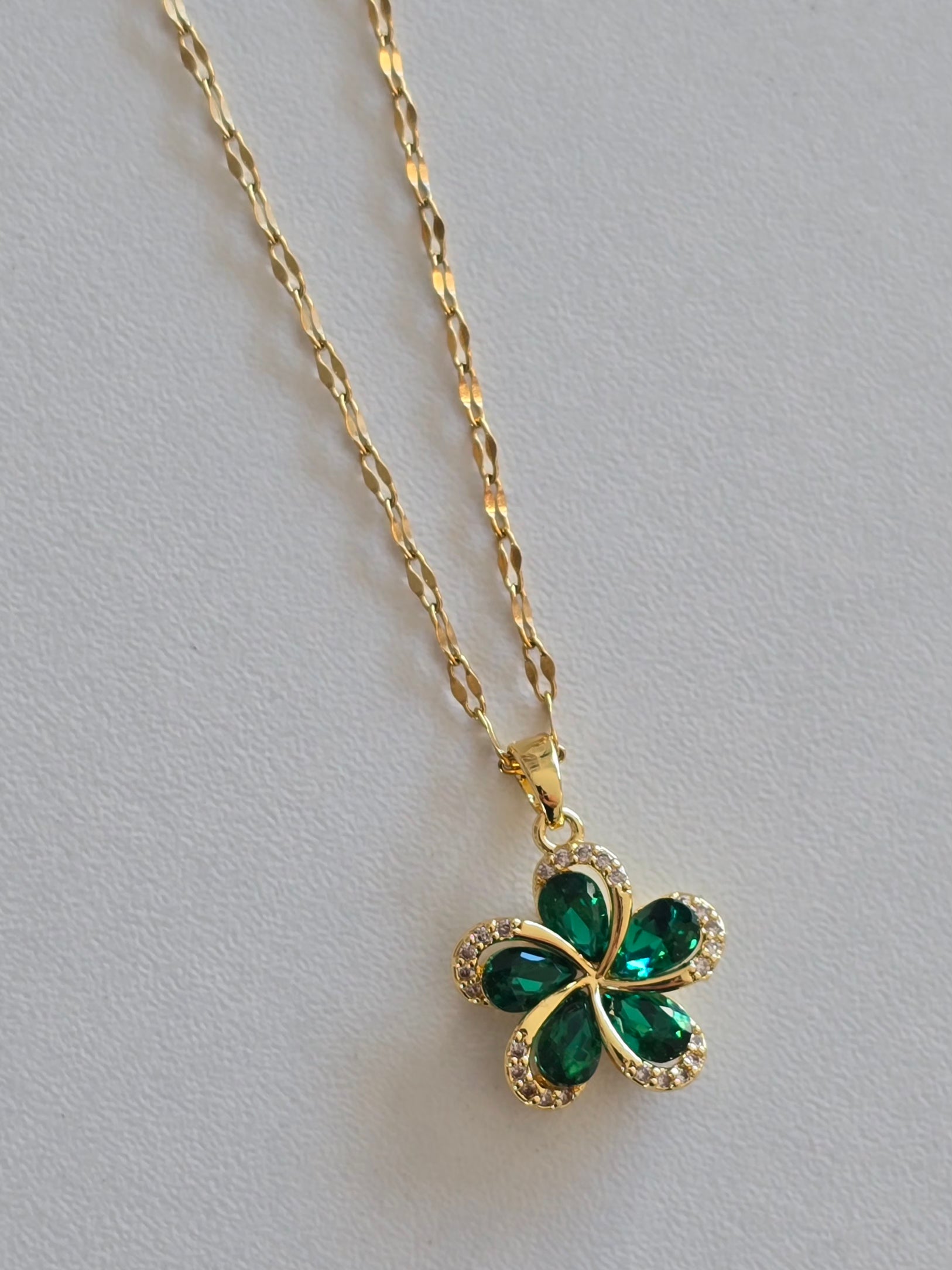 collier porte-bonheur élégant en acier doré avec fleur verte 