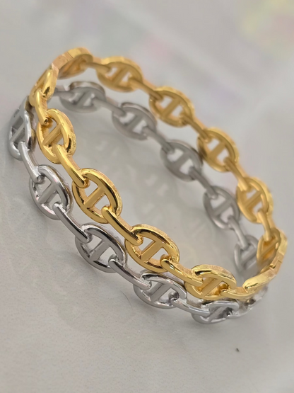 Bracelet rigide Livia en acier inoxydable, disponible en finition dorée ou argentée, design à. maillons élégants.