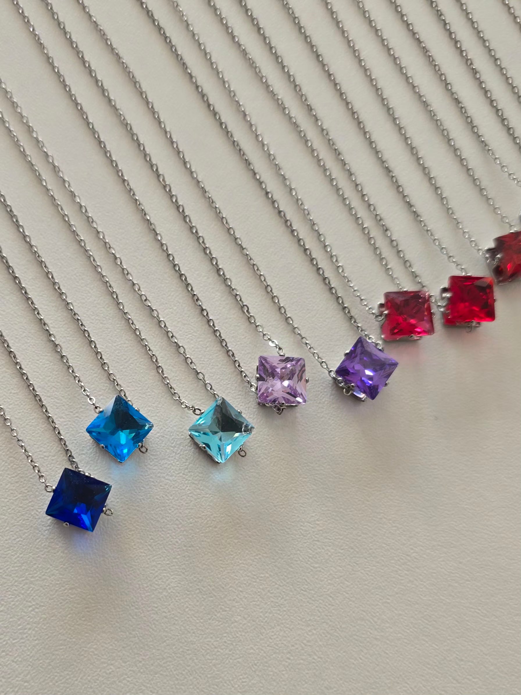 Colliers Lunéa alignés par couleurs avec pendentifs carré scintillants