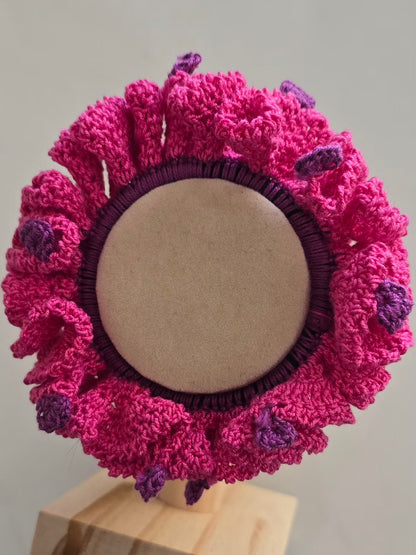 Accessoire cheveux rose et violet réalisé au crochet artisanal.
