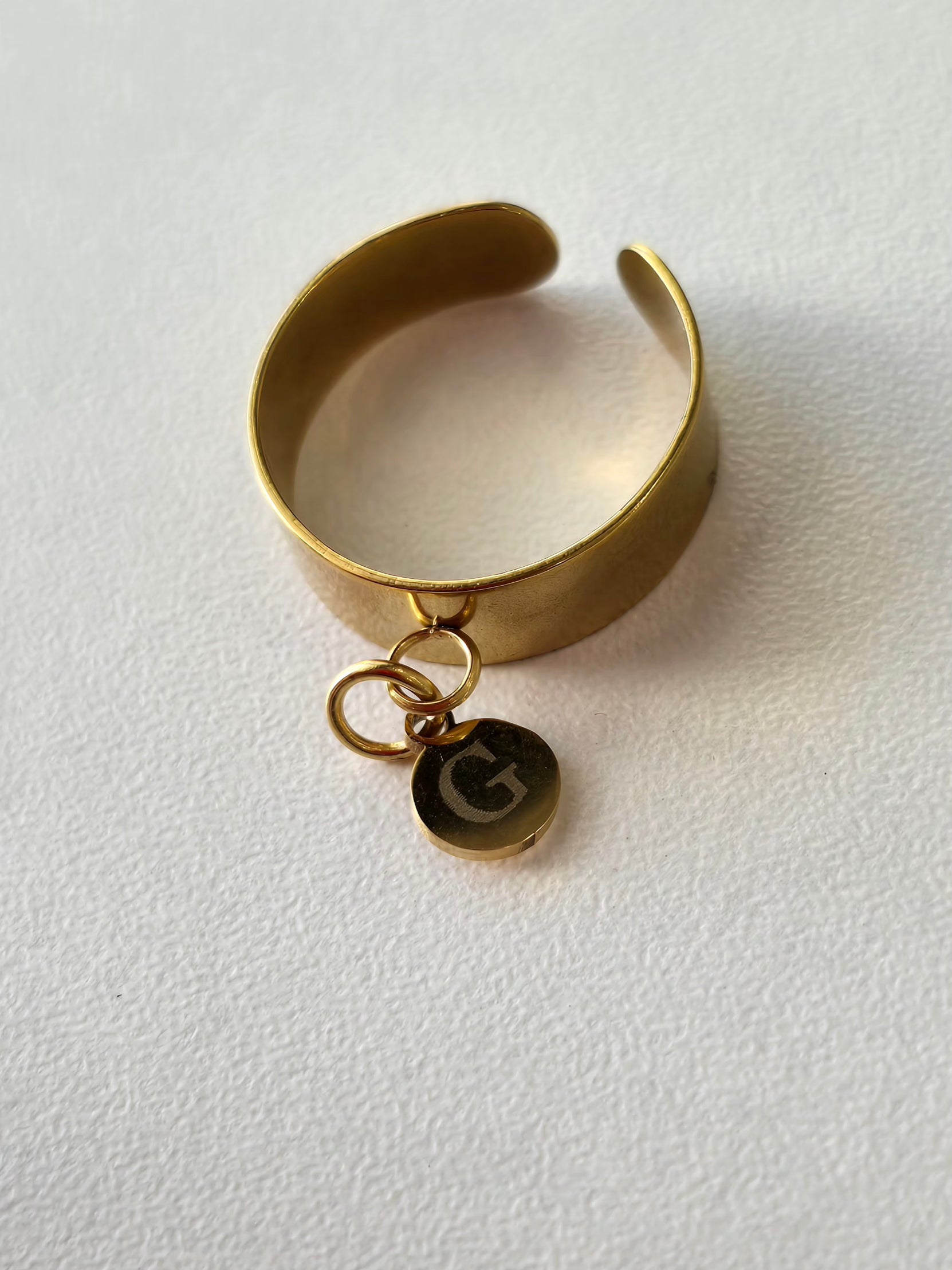 Bague en acier inoxydable avec breloque personnalisée, ici la lettre G