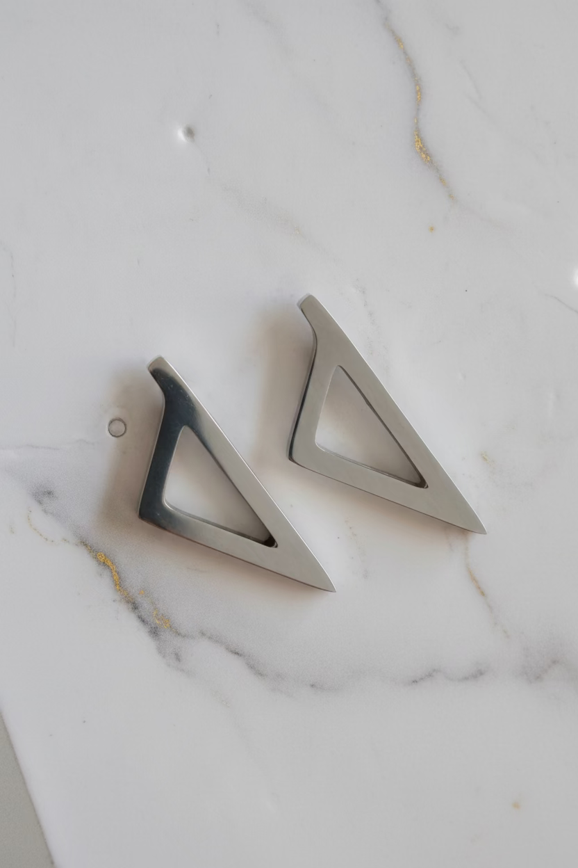 Boucles d'oreilles Corsica argentées en acier inoxydable au design géométrique triangulaire.