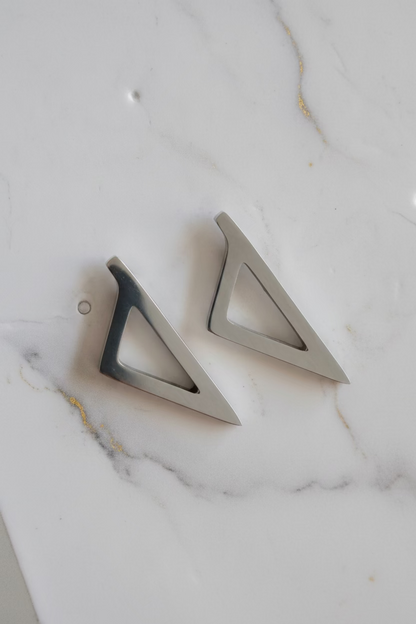 Boucles d'oreilles Corsica argentées en acier inoxydable au design géométrique triangulaire.