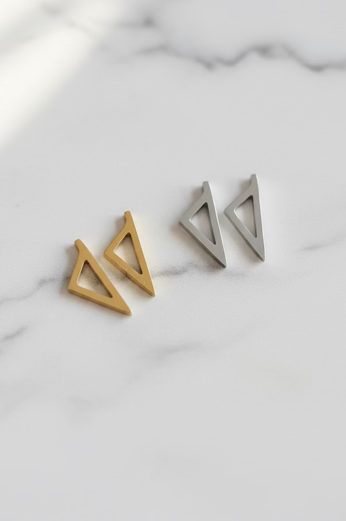 Boucles d'oreilles Corsica en acier inoxydable doré et argenté au design triangulaire ajouré.