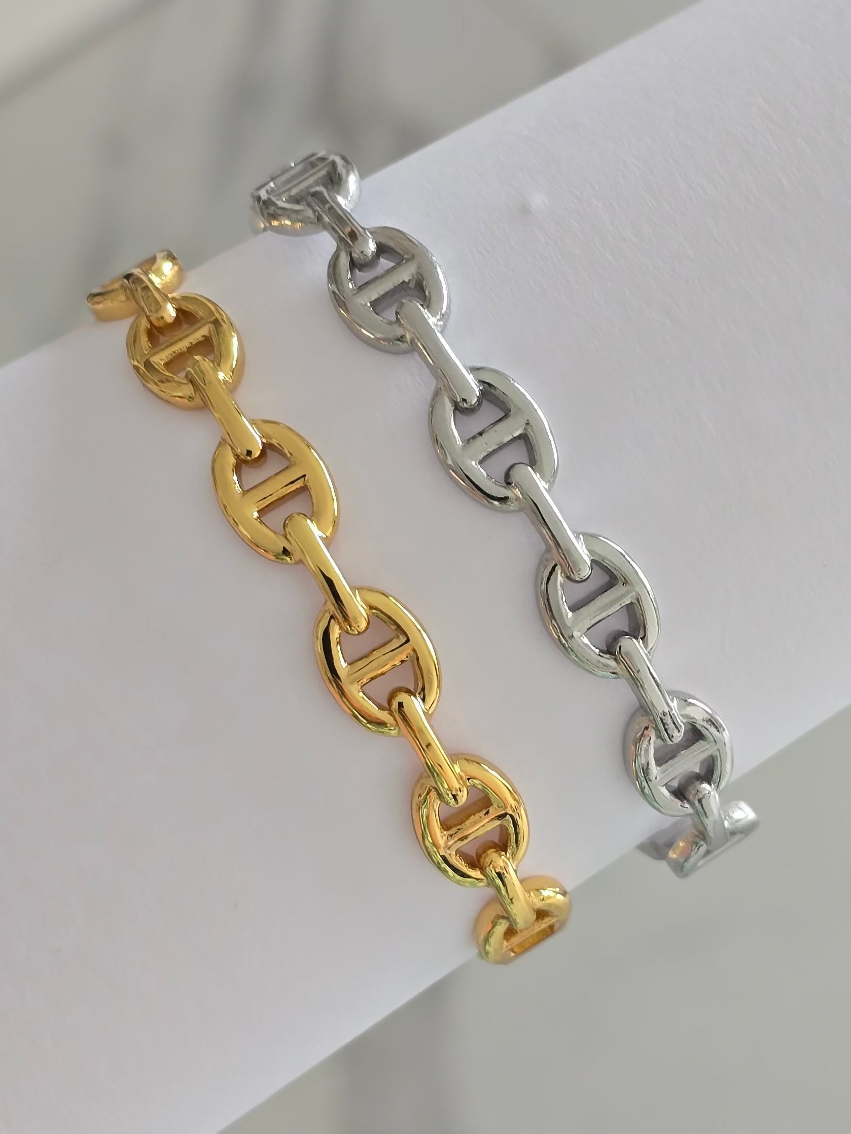 Deux bracelets rigides Livia en acier inoxydable, finition dorée et finition argentée.