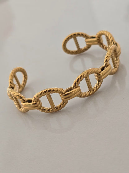 Détail du bracelet Maelys doré mettant en valeur ses maillons texturés.