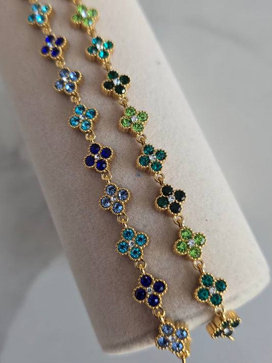 Gros plan sur les bracelets Princesa aux motifs floraux scintillants en strass bleus et verts
