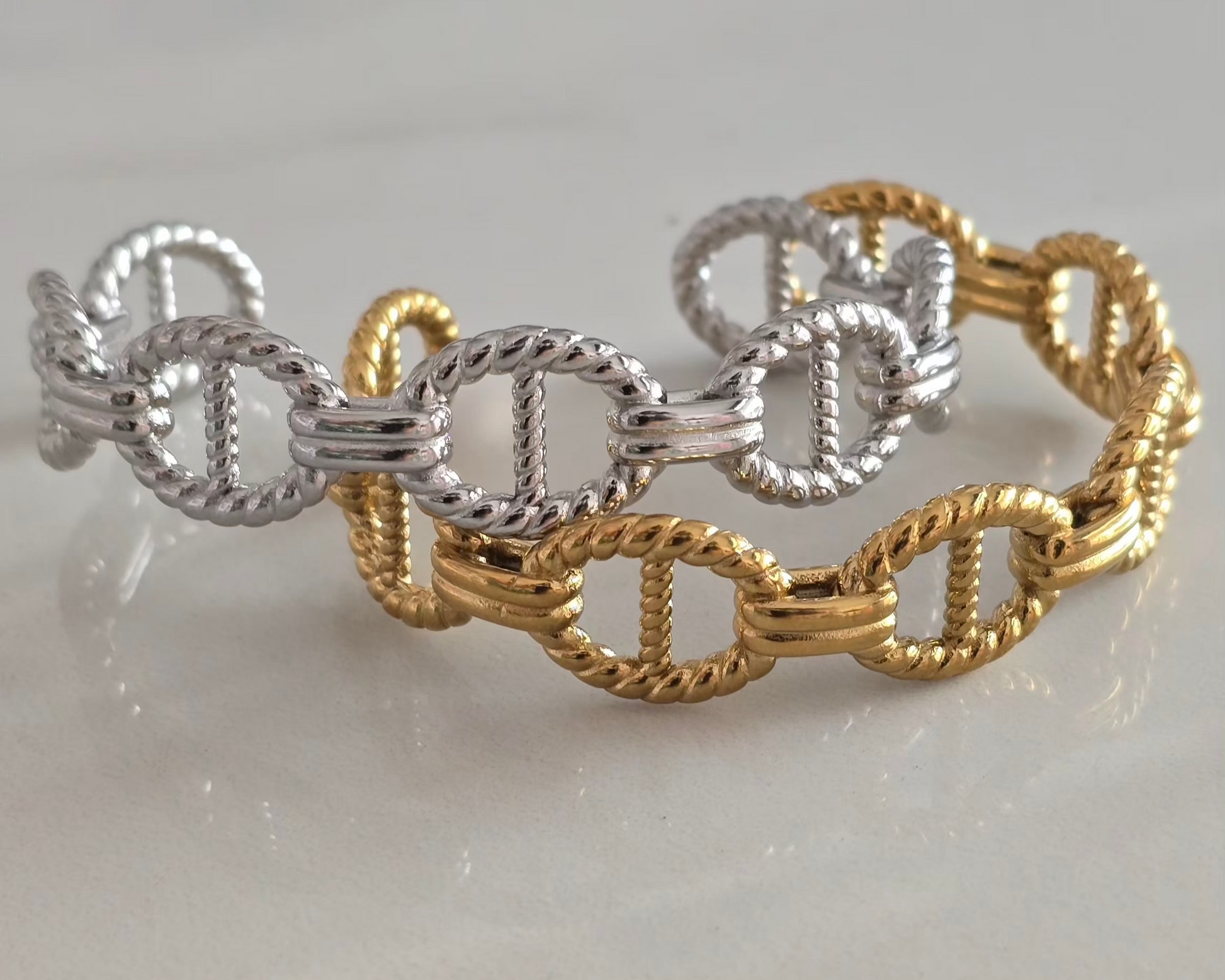 Bracelets Maëlys en acier inoxydable doré et argenté présentés côte à côte.