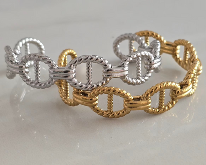 Bracelets Maëlys en acier inoxydable doré et argenté présentés côte à côte.