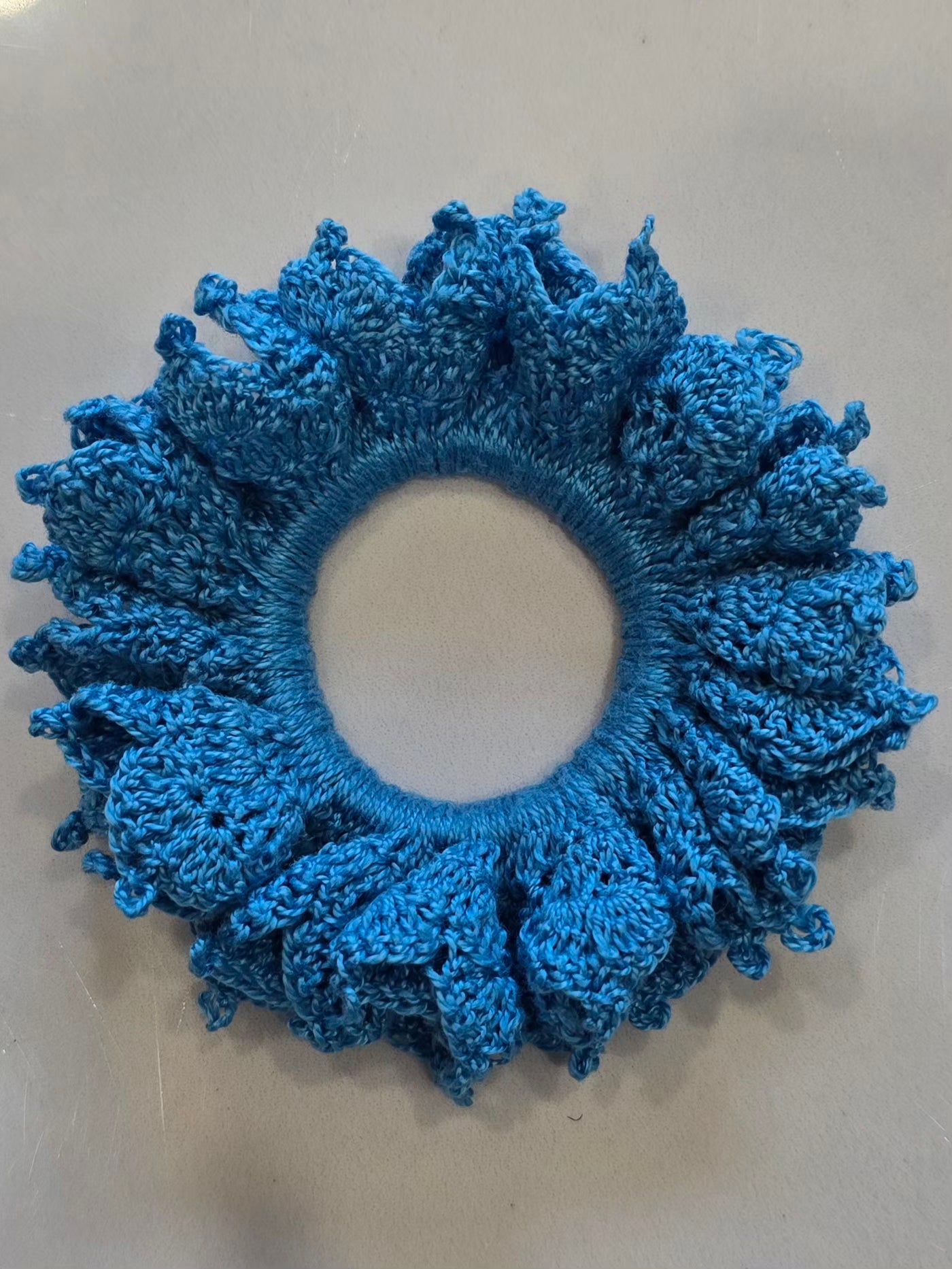 Chouchou bleu en crochet vu de dessus.