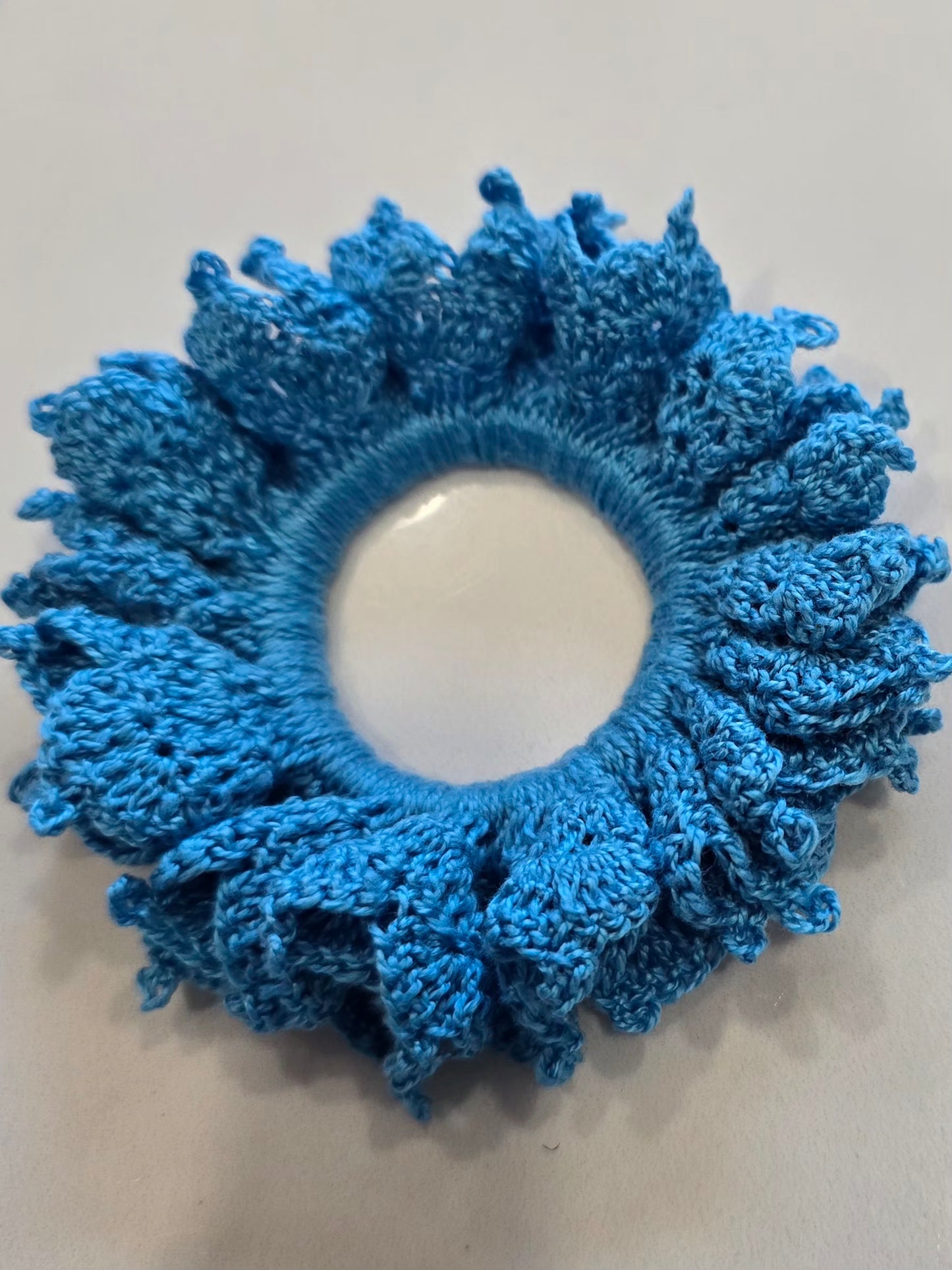 Vue de face du chouchou bleu en crochet artisanal.