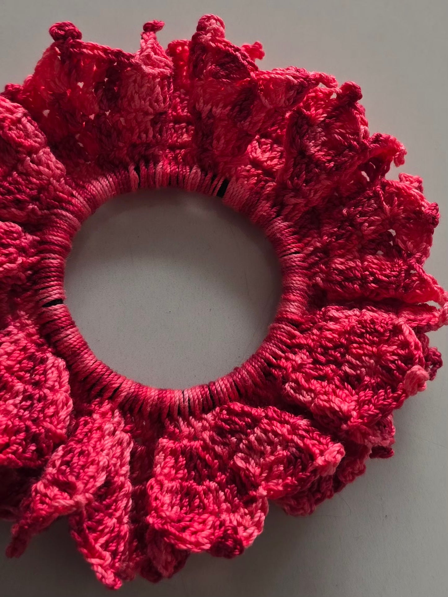 Chouchou volumineux en coton rose crocheté.