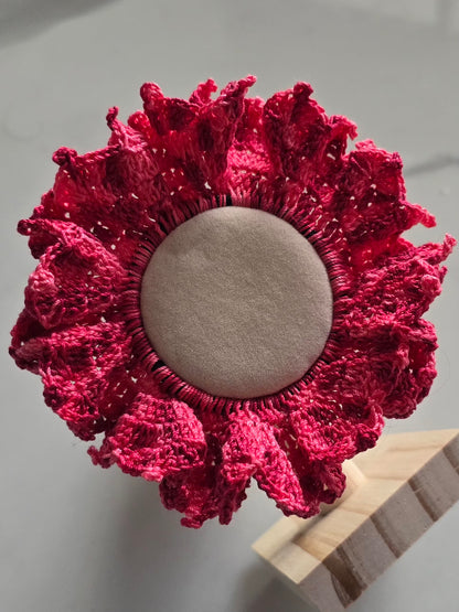 Chouchou en crochet rose avec volants décoratifs.