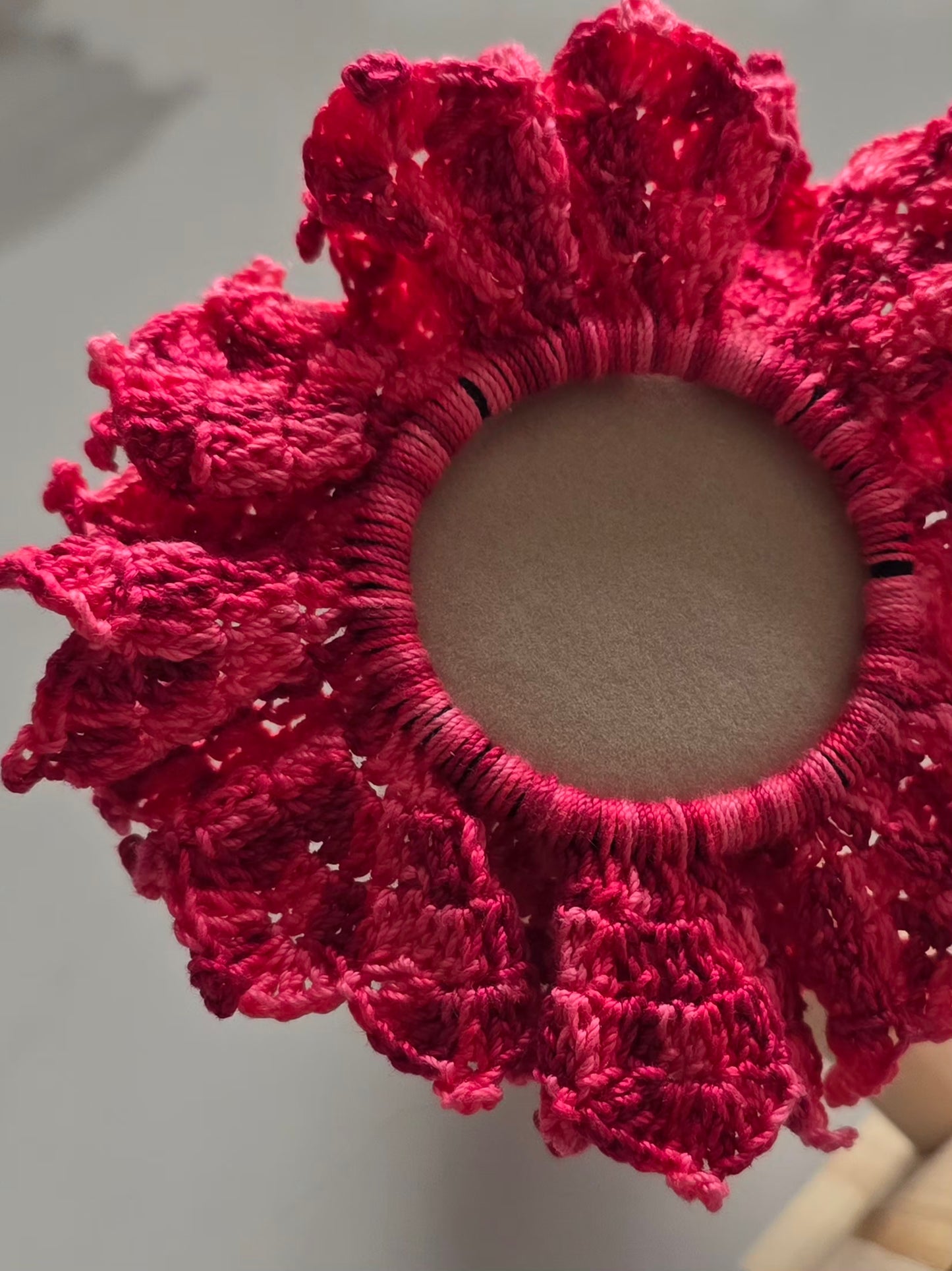 Finitions détaillées du chouchou rose en crochet.