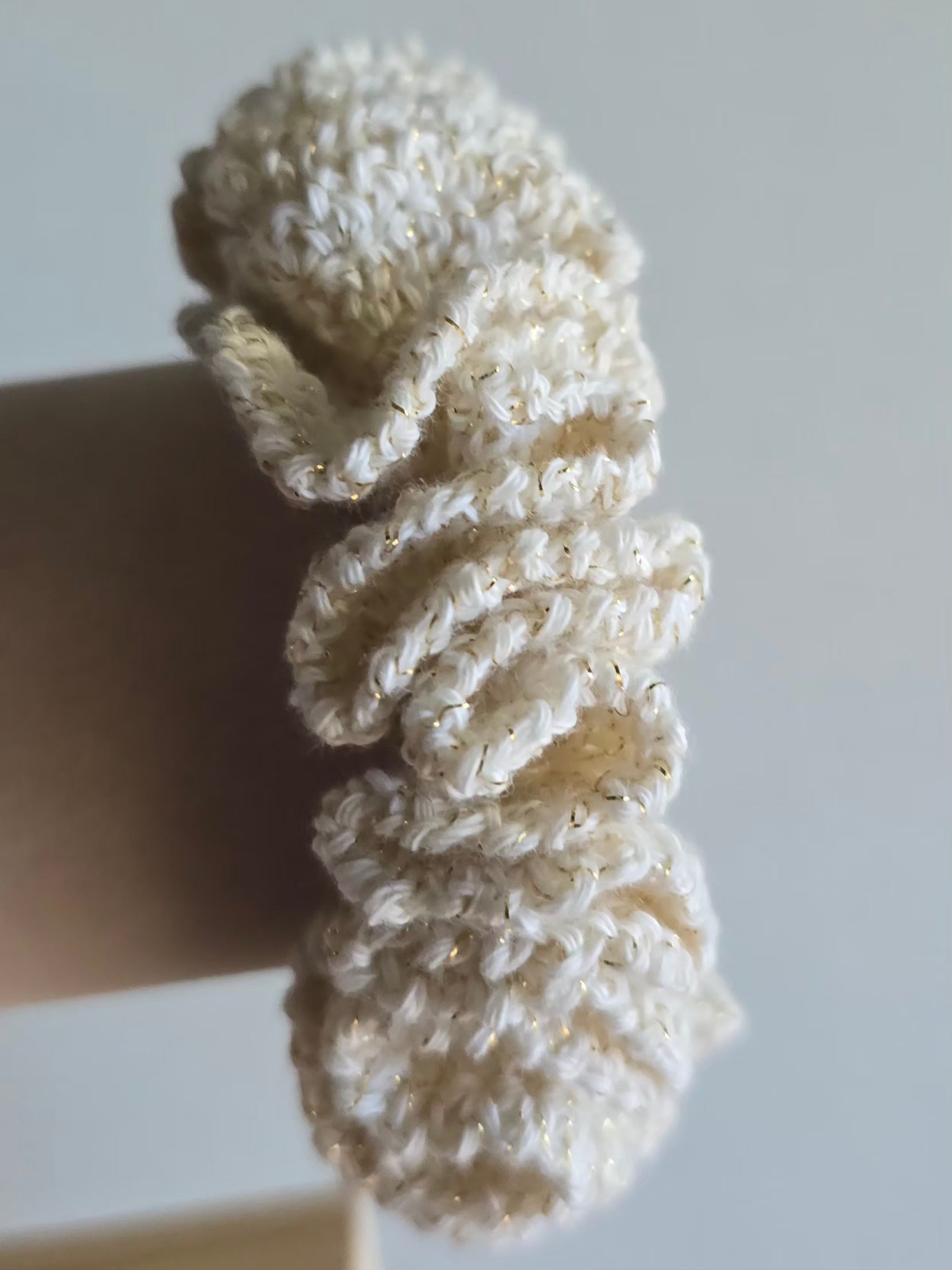 vue de côté d'un chouchou beige doré crocheté à la main