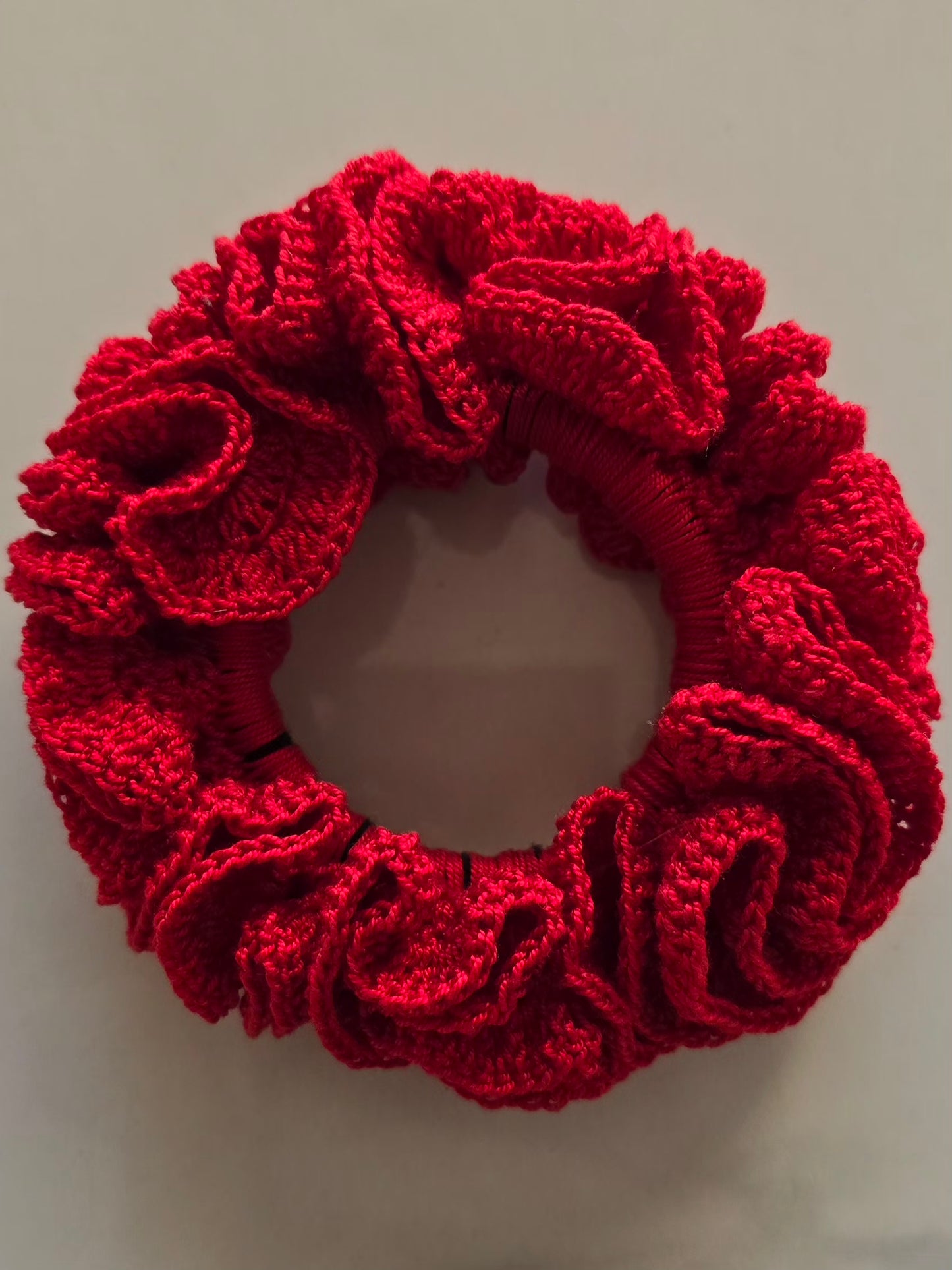 Chouchou rouge en crochet vu de face, finition artisanale.