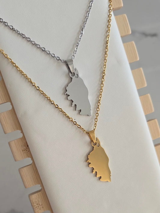 Collier Isula en acier inoxydable doré et argenté avec pendentif représentant la silhouette de la Corse sur présentoir. 