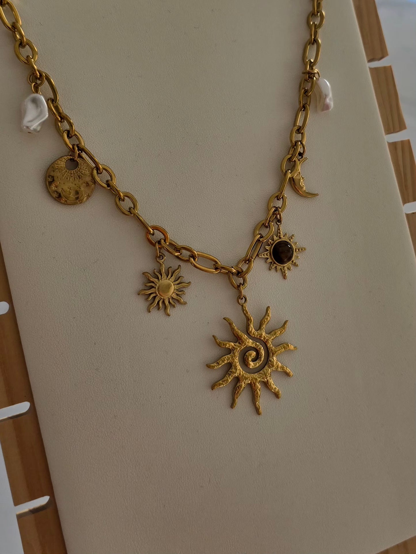 Vue détaillée du collier Soléa en acier inoxydable doré avec breloques célestes. 