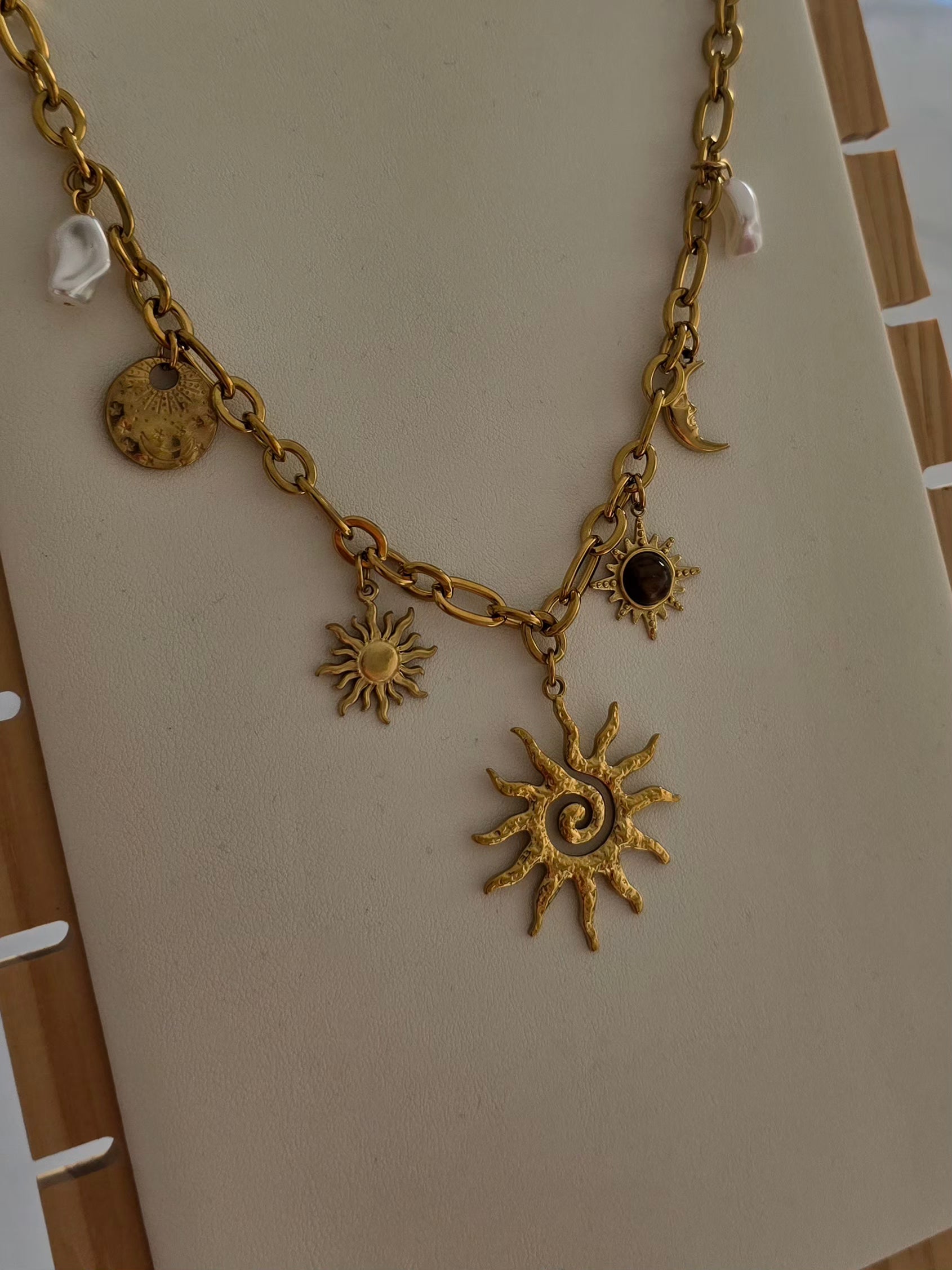 Vue détaillée du collier Soléa en acier inoxydable doré avec breloques célestes. 