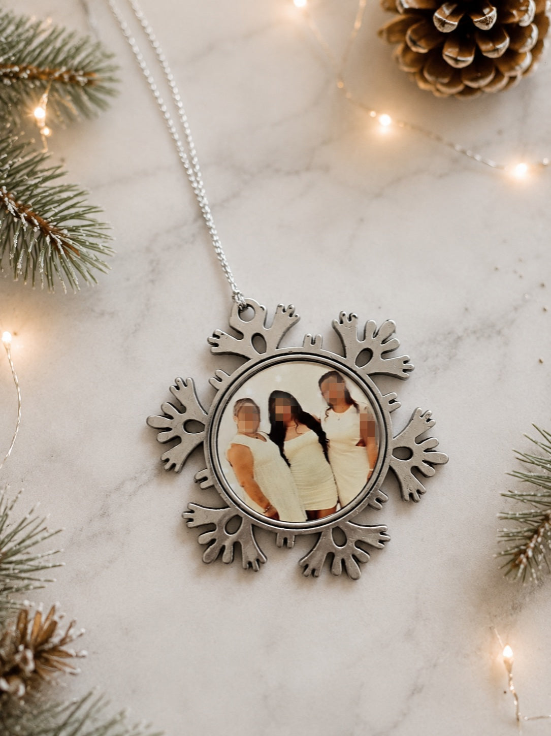 Flocon de Noël personnalisé en métal avec photo suspendu dans un sapin.