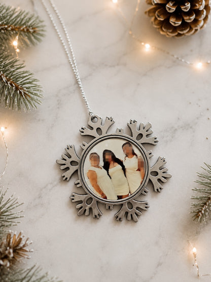 Flocon de Noël personnalisé en métal avec photo suspendu dans un sapin.