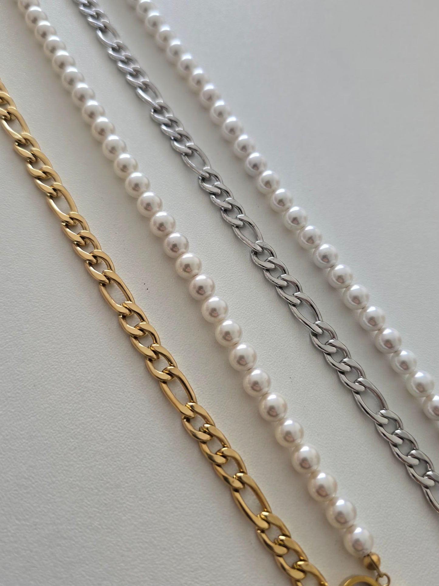 Accessoire élégant associant perles et chaîne brillante