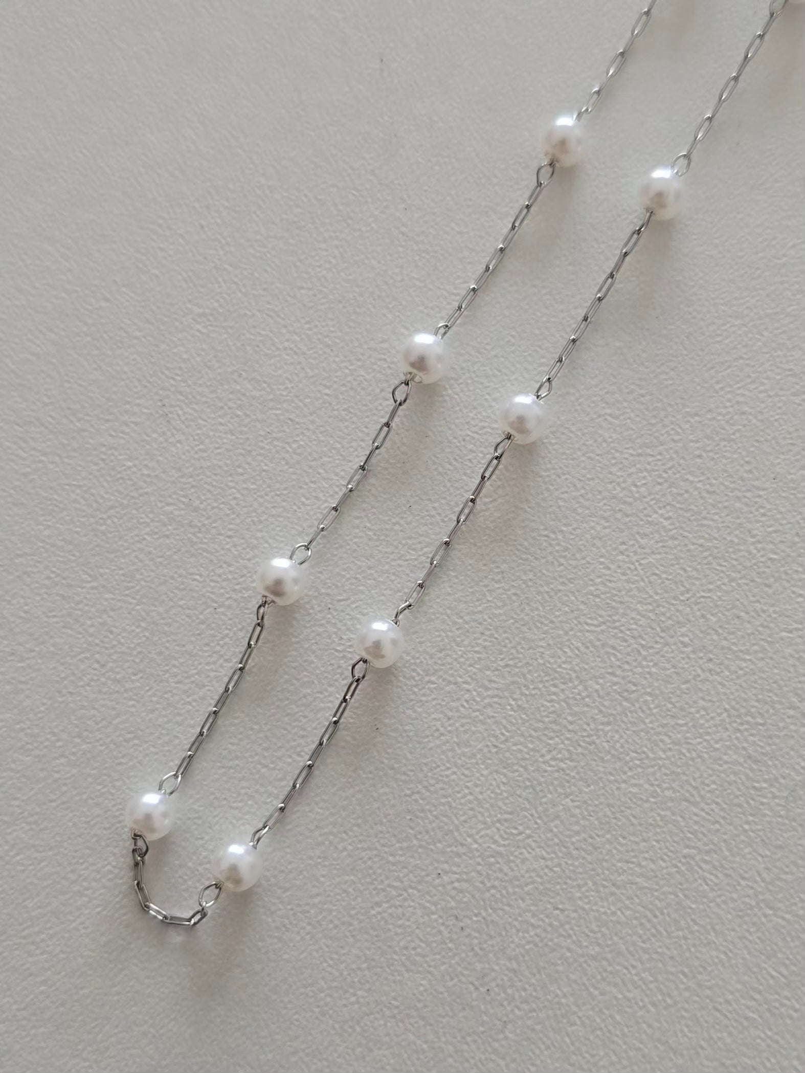L'éclat des perles blanches du collier Perla