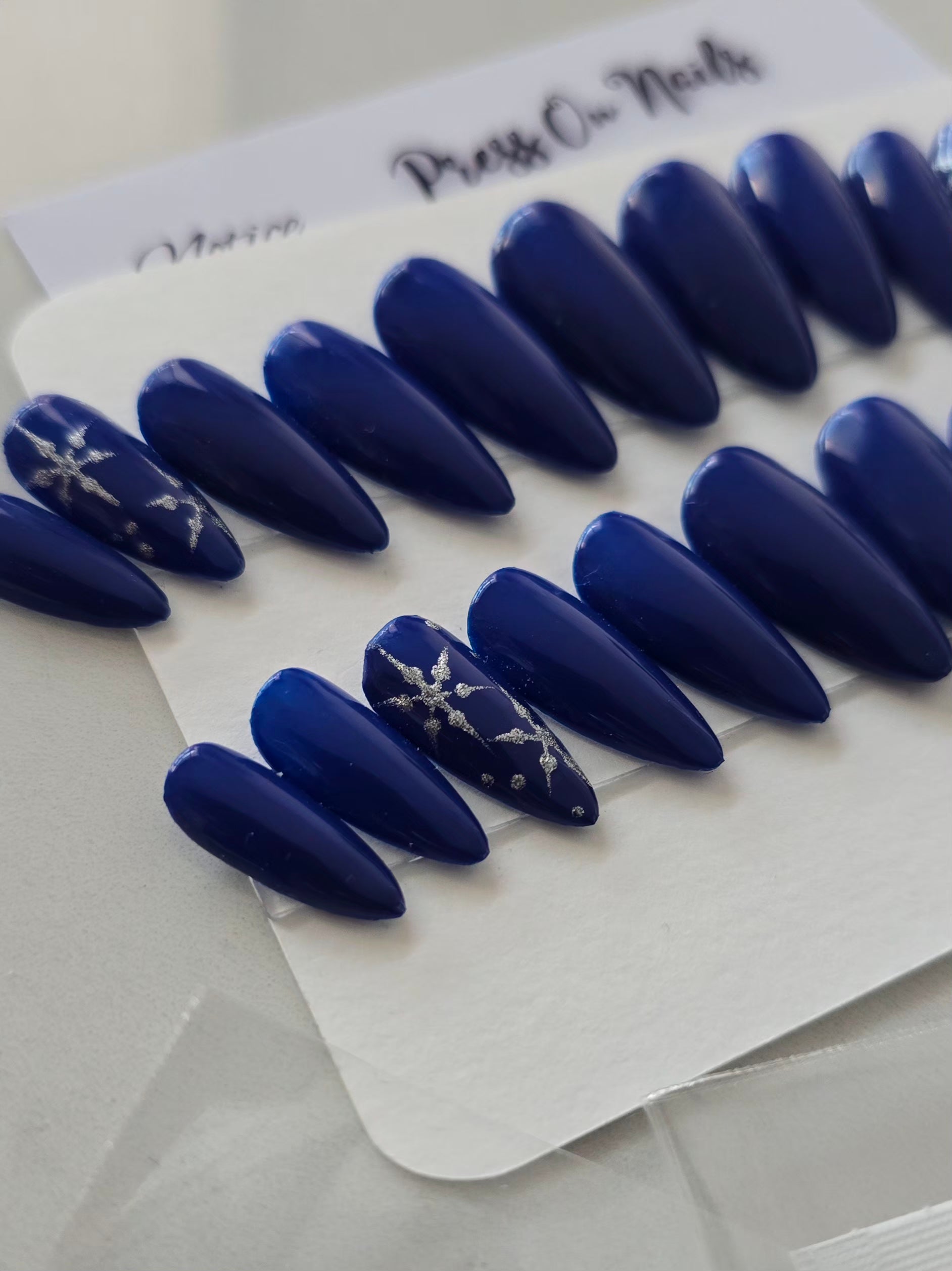 PRESS ON NAILS bleus nuit décorés de flocons argentés dessinés à la main, inspirés des nuits d'hiver.