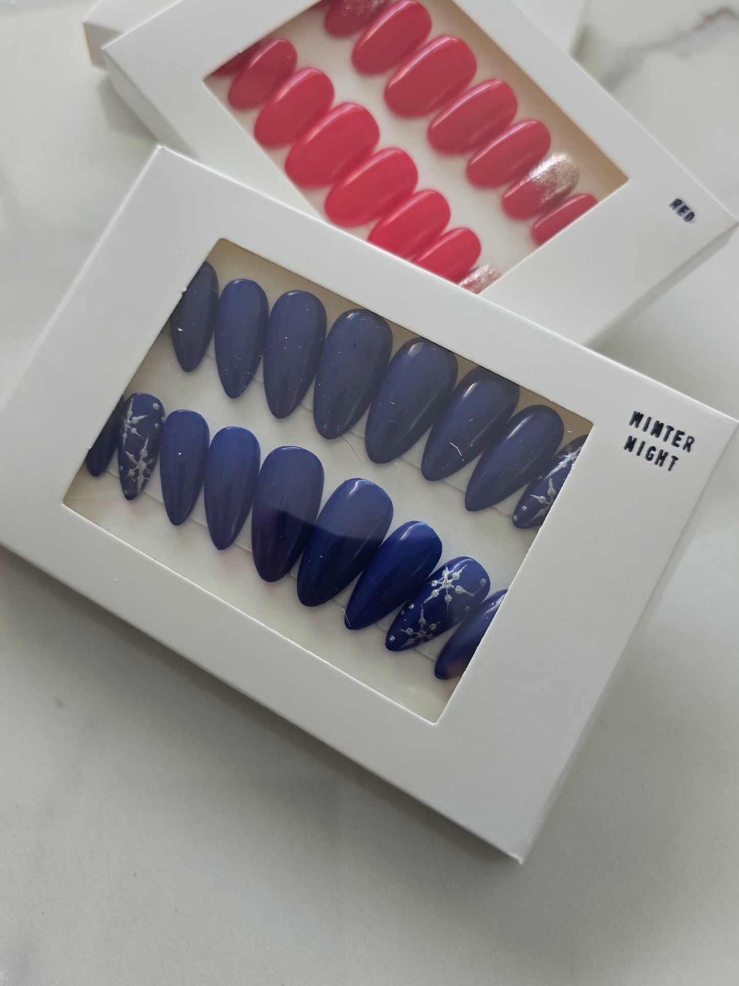 Boîte blanche contenant le kit PRESS ON NAILS Winter Night - manucure rapide et raffinée à domicile.